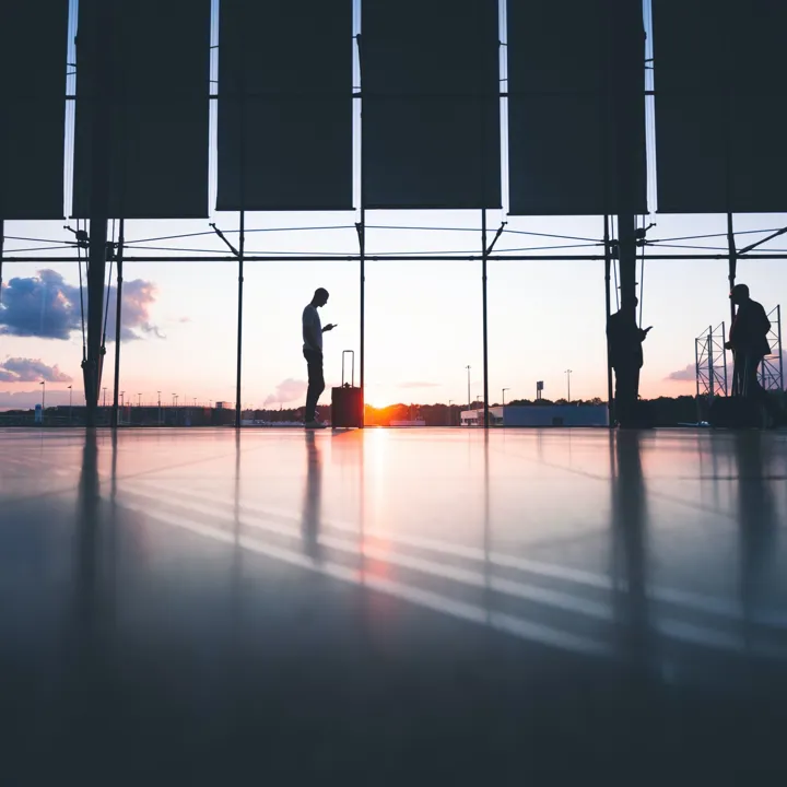 Man Waiting In An Airport Next To His Suitcase