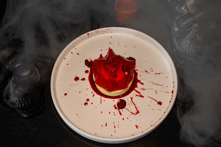 Halloween Inspired Dessert On A White Plate With Smoke Around It