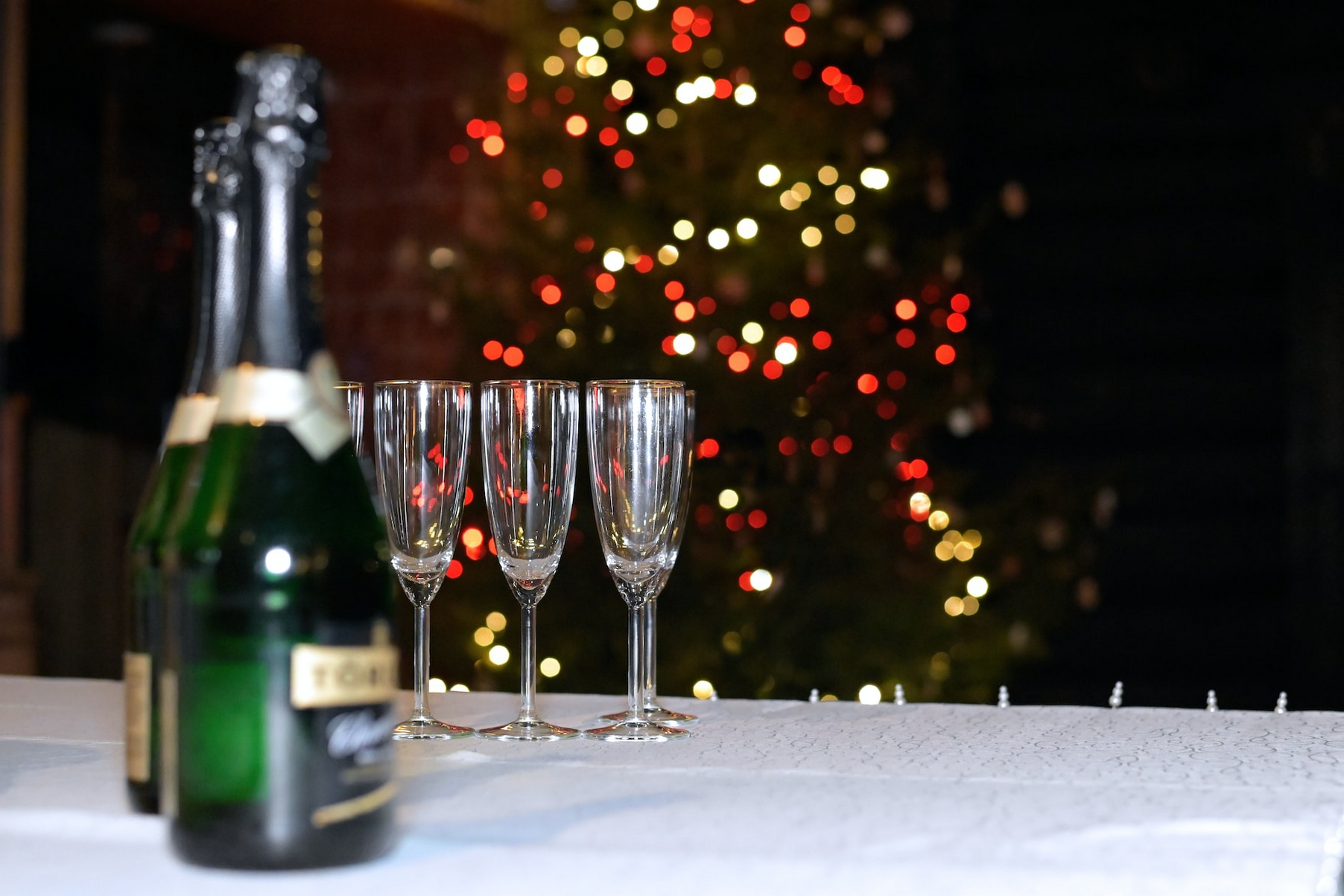 Champagne Glasses And Bottles In Front Of A Christmas Tree