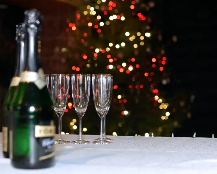 Champagne Glasses And Bottles In Front Of A Christmas Tree