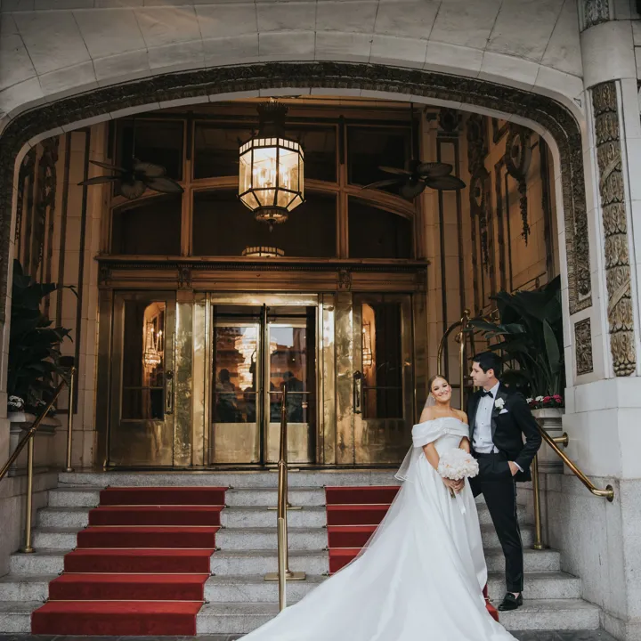 Bride And Groom Standing On The Steps Of The Entrance To The Roosevelt New Orleans